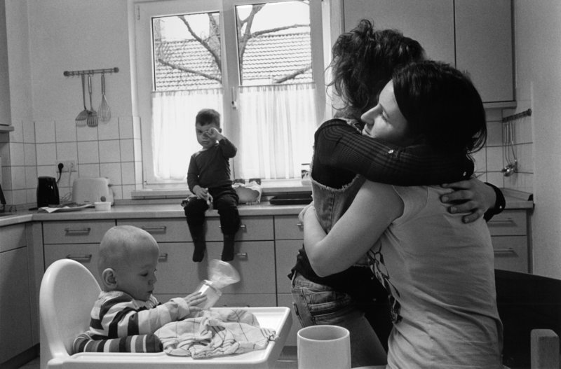 Foto: Schwarz-Weiß-Aufnahme mit Mutter und drei Kindern in der Küche.