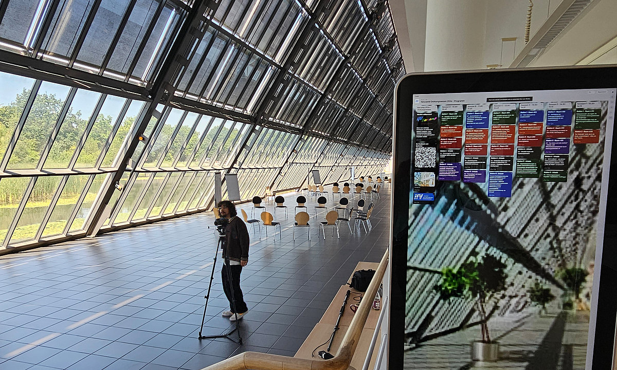 Bildschirm mit Themenpost-Its im Glasfoyer.