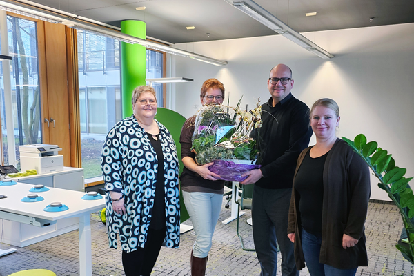 Vier Personen mit Blumenstrauss