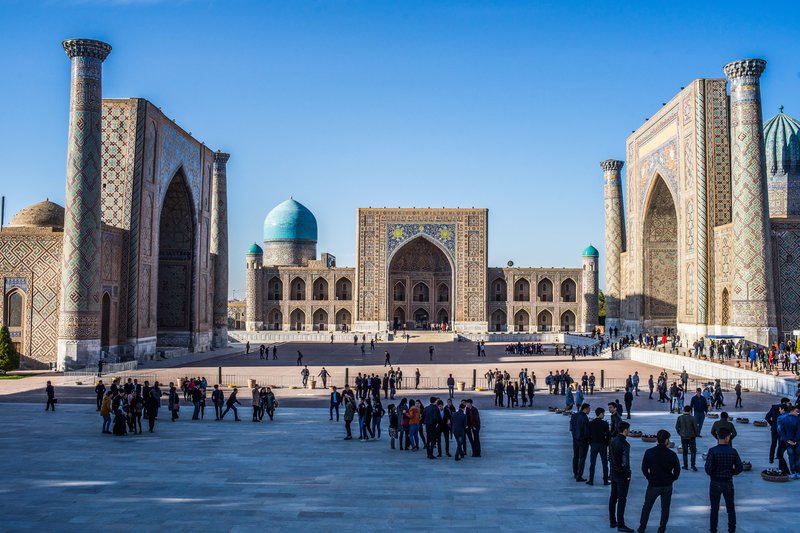 Foto: Menschenansammlung auf dem Registan Platz zwischen imposanten Bauwerken..
