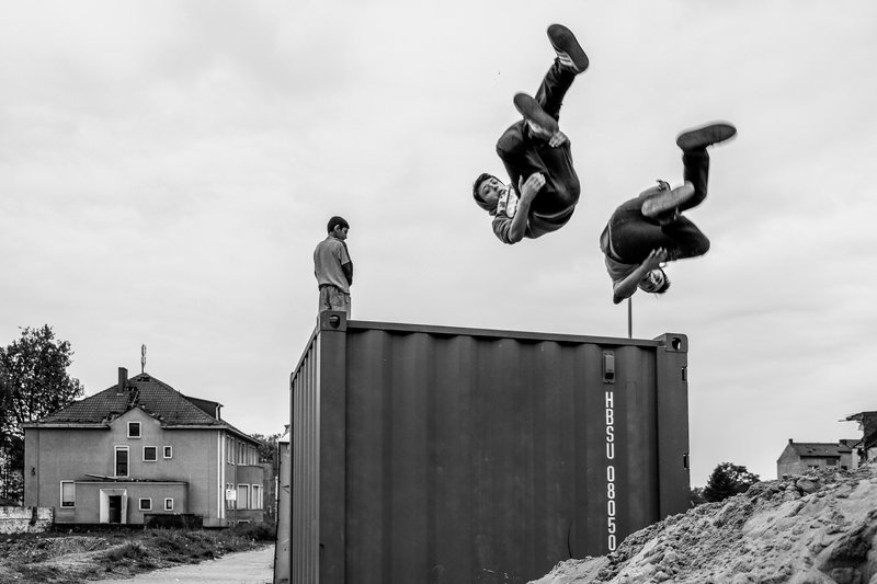 Foto: Zwei Jungen springen von einem Container.