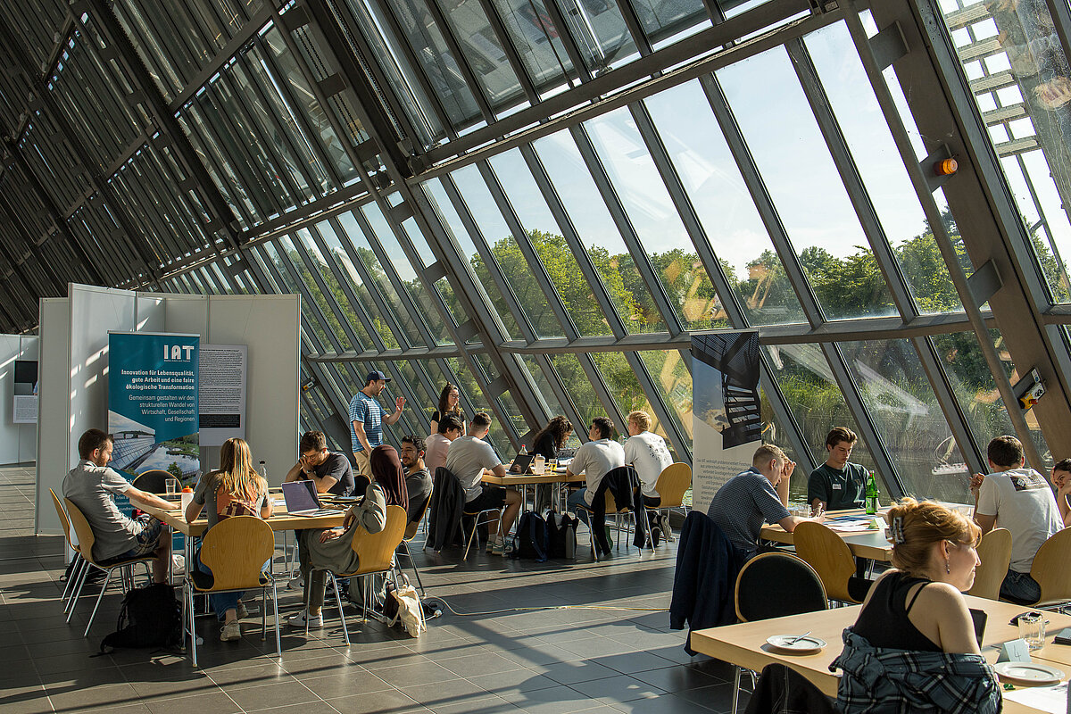 Studierende arbeiten an Tischen